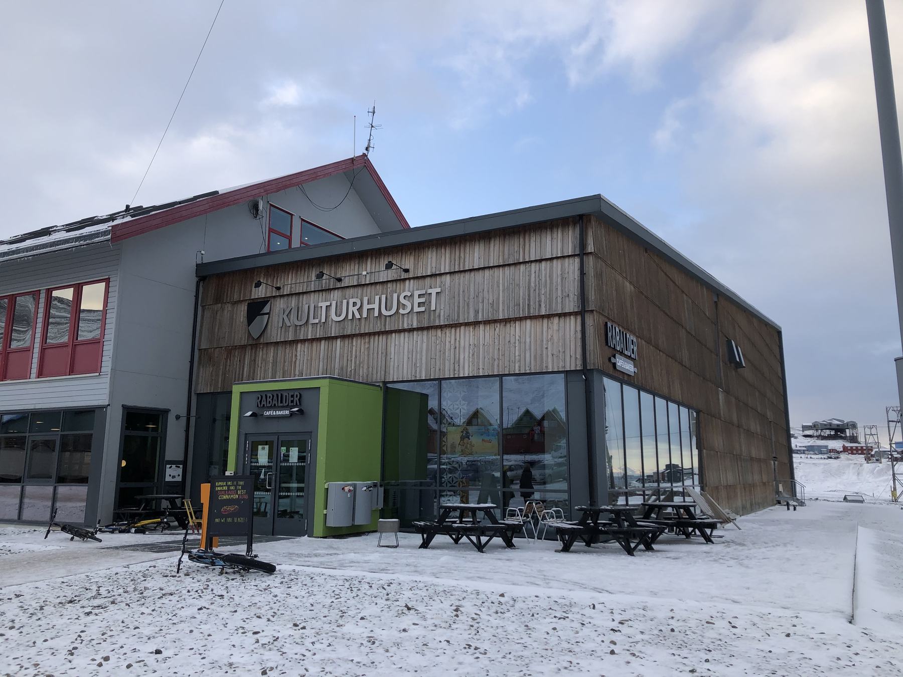 Kulturhuset in Longyearbyen on a snowy day, with its wooden facade and glass front